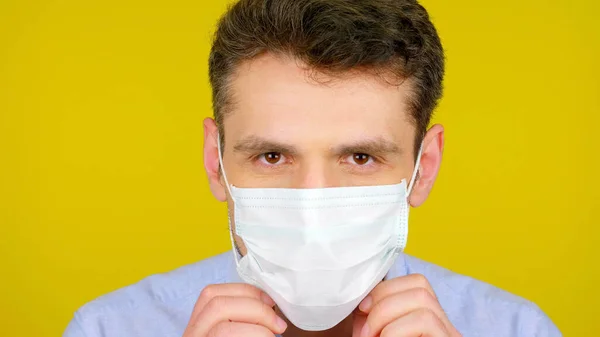 Közelkép fertőző betegség orvos felvesz egy védő orvosi maszk — Stock Fotó
