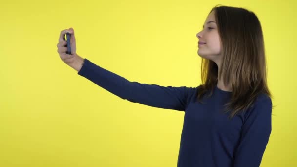 Meisje blogger poseert en neemt video aan abonnees op smartphone selfie camera — Stockvideo