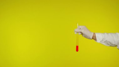 Lateks eldiven koruması kırmızı maddeli cam bir tüp gösteriyor.