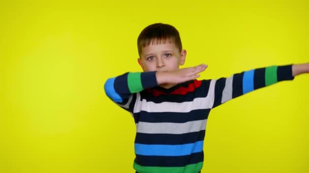 Little child boy maakt een dansbeweging DAB op gele achtergrond met kopieerruimte — Stockvideo