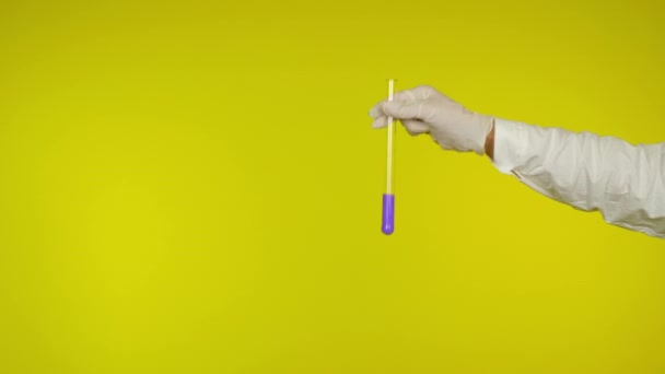 Ruka v latexové rukavici ochrana ukazuje skleněnou trubici s fialovou látkou — Stock video