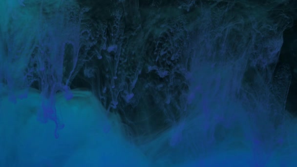 Blått och grönt bläck blandas i vatten, virvlande mjukt under vattnet — Stockvideo
