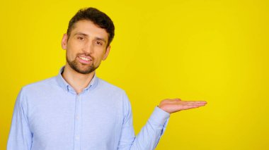 Gülümseyen bir adam avucunun içinde hayali bir ürün gösterir.