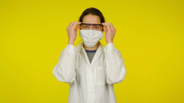 Koruyucu tıbbi maskeli bulaşıcı hastalıklar doktoru gözlerinden gözlük çıkartıyor.
