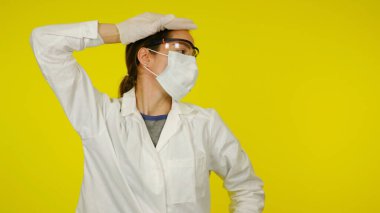 Tıbbi maskeli, gözlüklü ve lateks eldivenli yorgun bulaşıcı hastalıklar doktoru.