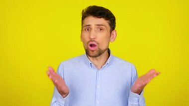 Duygusal adam hayır der ve sarı arka planda ellerini sıkar.