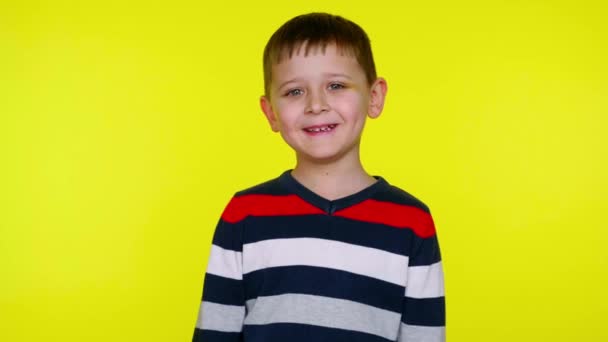 Маленький мальчик смеется на желтом фоне с копировальным пространством — стоковое видео