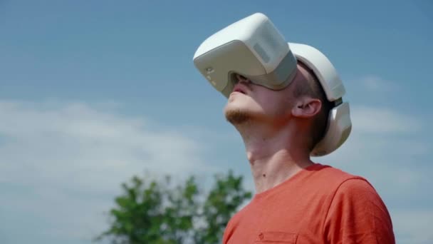 Man in een virtual reality helm steekt zijn hoofd op — Stockvideo