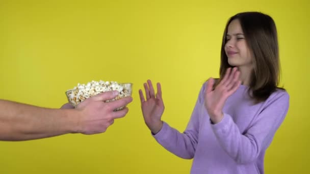 Teenie-Mädchen im rosa Pullover verweigert Popcorn in Glasschale beim Händeschütteln und Kopfschütteln — Stockvideo