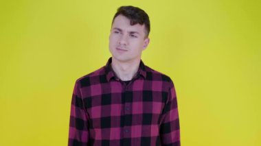 Düşünceli adam sağa bakar ve sarı bir arka planda almayı düşünür.