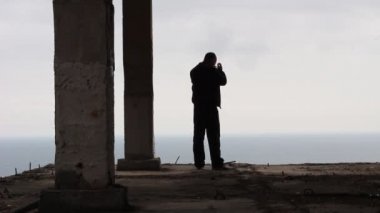 Yüksek bir binanın kenarında duran üzgün bir adam silüeti. Olgun adam keder içinde. Stres kavramı