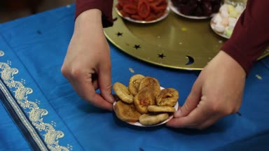 Iftar: Akşam yemeği sevindirdi. Müslüman aile. Güneşin battığı zaman, tablo tarihleri, tatlılar ve kurutulmuş meyve ile doludur