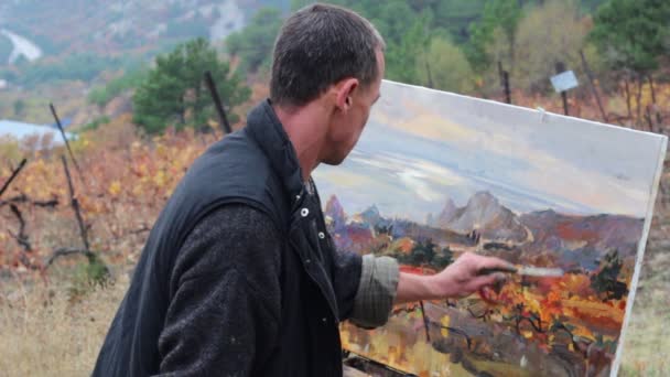 プロの芸術家は 油絵の具を使用してキャンバス上の画像を描画します 風景油絵 秋のブドウ畑 — ストック動画