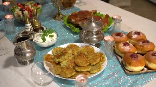 Un délicieux dîner. Paramètres de table pour Hanoukka. Traditions juives festives. Hanoukka fête avec la famille et les amis. Aliments frits comme les crêpes de pommes de terre (latkes) et beignets (sufganiyot) )