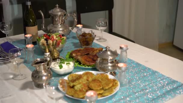 Dîner de famille festif. Repas Hanoukka traditionnel. Sur la table, il y a une nourriture juive casher symbolique frite. Latkes, beignets confits, produits laitiers, salade au fromage, gelée Hanoukka au chocolat 