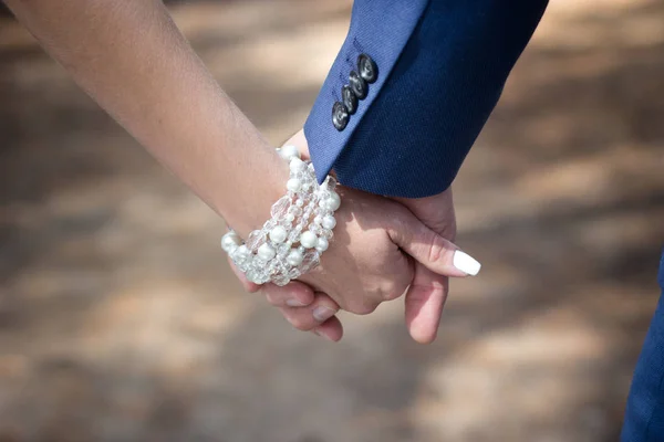 the bride and groom are holding hands in the forest