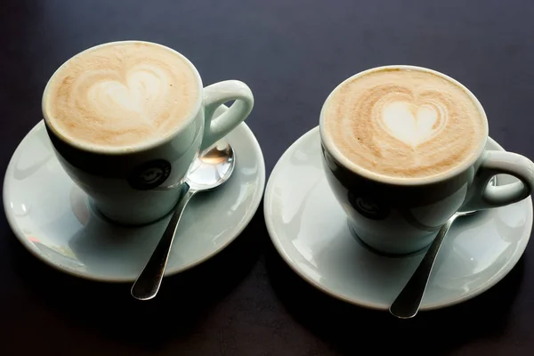 two cups of coffee with a heart