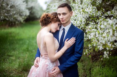 Gelin ve Damat Düğün çiçek bahçeleri fonunda Giydir