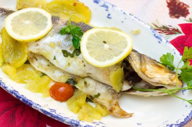 Deniz levreği pişmiş patates ve domates ile