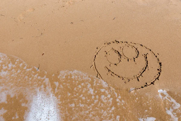 Sonrisa dibujar en la orilla del mar — Foto de Stock