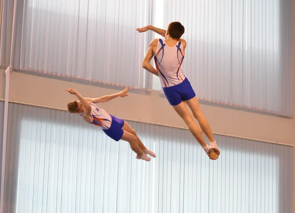 Orenburg, Rusia 4 de diciembre de 2016: Los chicos compiten en saltos síncronos en un trampolín — Foto de Stock