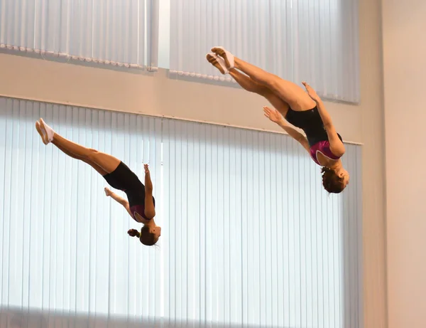 Orenburg, Rússia 4 de dezembro de 2016: Meninas competem em saltos síncronos em um trampolim — Fotografia de Stock