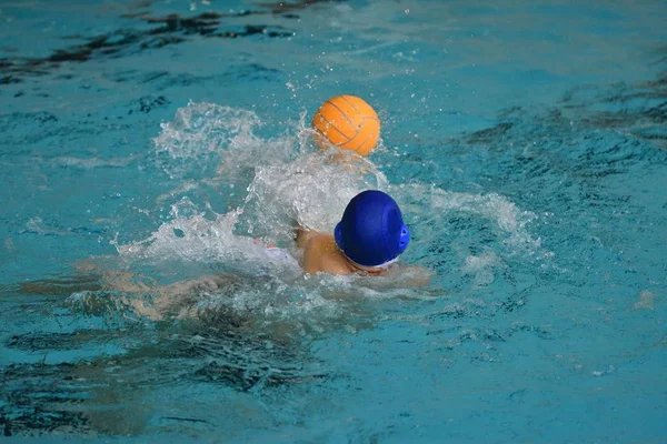 Pojkarna spelar i vattenpolo — Stockfoto