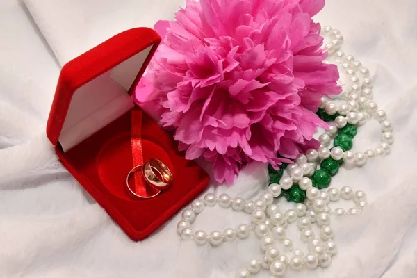 Dva snubní prsteny a Pivoňka květ. — Stock fotografie