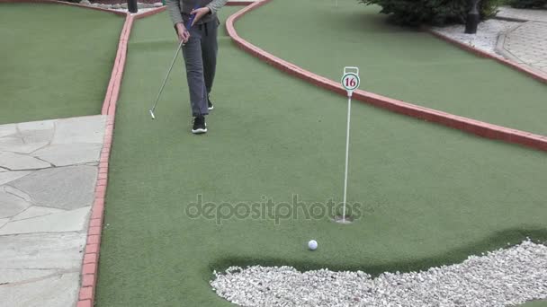 Niño jugando en minigolf — Vídeo de stock