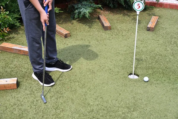 Menino brincando em minigolfe — Fotografia de Stock