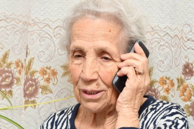 Yaşlı bir kadın ile bir cep telefonu