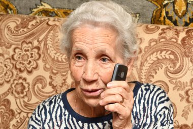 Yaşlı bir kadın ile bir cep telefonu