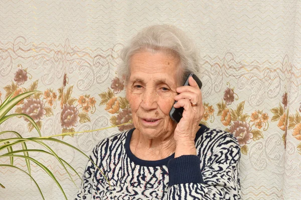 Une femme âgée avec un téléphone portable — Photo