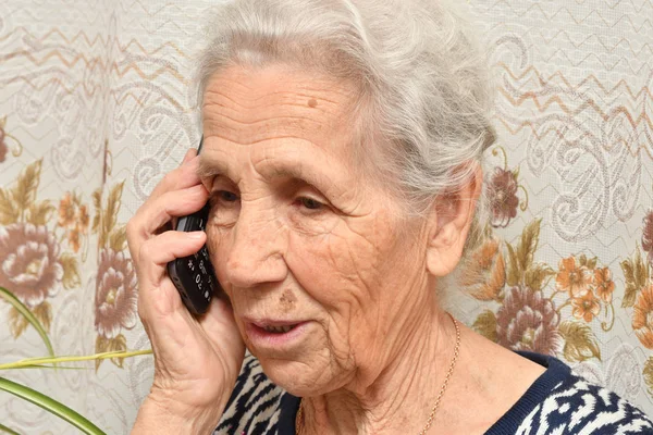 Yaşlı bir kadın ile bir cep telefonu