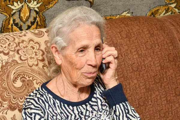 Yaşlı bir kadın ile bir cep telefonu