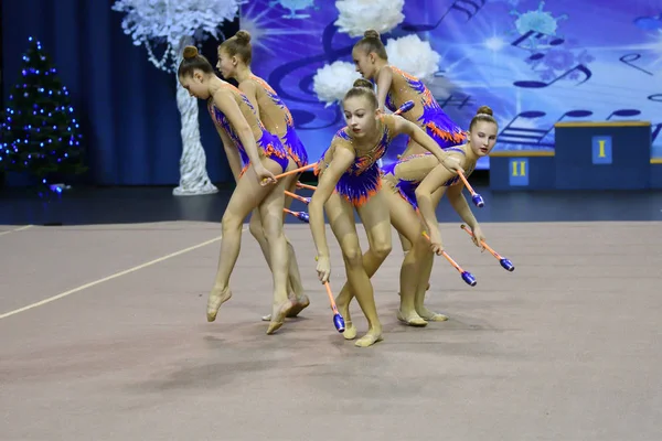 Orenburg, Russia - November 25, 2017 year: girls compete in rhythmic gymnastics perform exercises with sports clubs — Stock Photo, Image