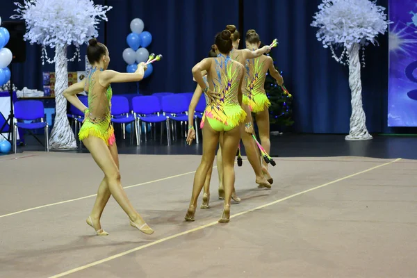 Orenburg, Russia - November 25, 2017 year: girls compete in rhythmic gymnastics perform exercises with sports clubs — Stock Photo, Image