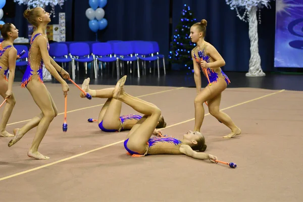 Orenburg, Russia - November 25, 2017 year: girls compete in rhythmic gymnastics perform exercises with sports clubs — Stock Photo, Image