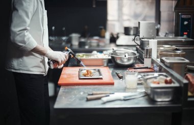 Restoran şef aşçı hazırlanıyor somon fileto flambe.