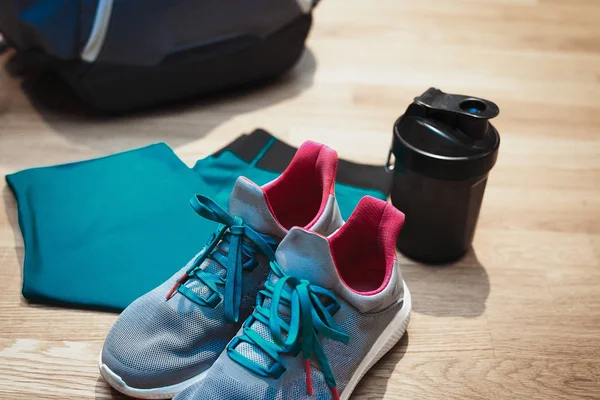 Chaussures de sport pour filles et support de tasse de sport à côté de vêtements de sport bleus et sac à dos . — Photo