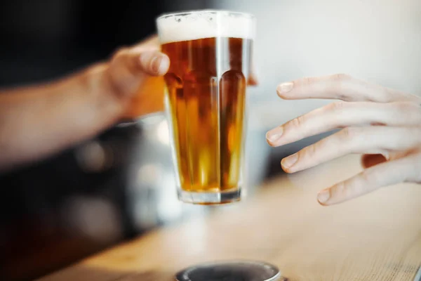 Bartender man gives beer glass to a customer. — Stock Photo, Image
