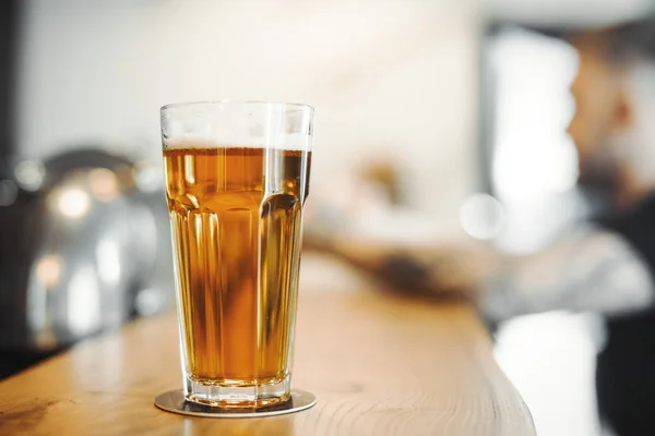 Cerveza de vidrio está en el mostrador de bar . — Foto de Stock