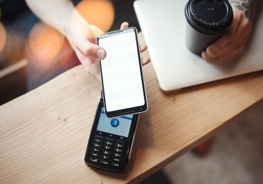 Genç kadın üzerinden ödeme terminal ve cep telefonu kafede öder.