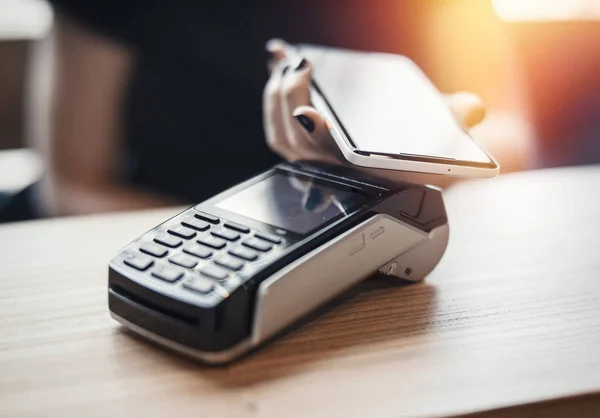 Genç kadın ödeme terminal ve cep telefonu öder.