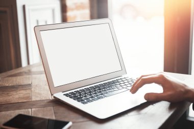 Ortak çalışma içinde laptop üzerinde çalışan genç adam.