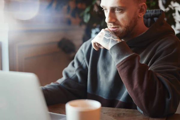 Joven pensativo trabajando en el ordenador portátil en co-working — Foto de Stock