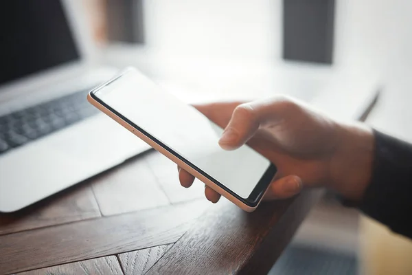 Ung man håller mobiltelefon och arbetar på Pc. — Stockfoto