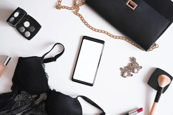 Flat Lay of Mobile Phone With Blank Screen Near Lingerie, Earrings, Cosmetics, Perfume, Make up Brush, Clutch Bag. Getting ready For Party