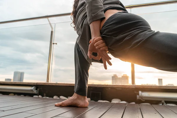 Man Practising Yoga Outdoor At Skyscraper Roof On Sunset Background. Parsva Triconosana — 图库照片