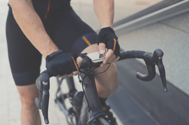 GPS Navigator ve Smart Watches ile Road Motosiklet Barını kapatın. Modern ve Çağdaş Spor Bisikleti Gadget 'ları. Atletik Bisikletçi Şehir Sokakları 'nda Spor Bisikleti Sürüyor